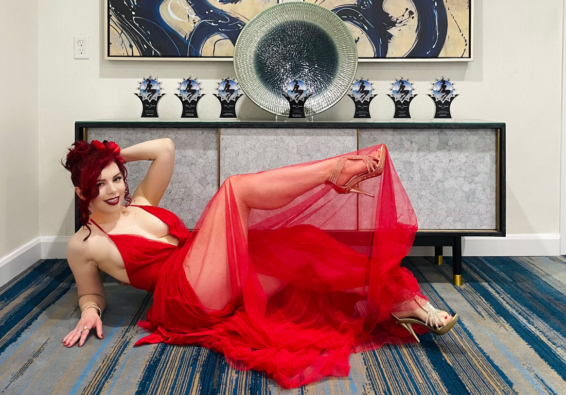 Ludella Hahn posing with her 7 Trophies at the 2022 Fetish Awards